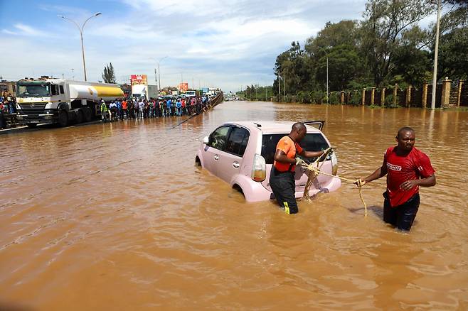 지난 1일 케냐 수도 나이로비에서 사람들이 홍수에 빠진 자동차를 끌어당기고 있다. [신화/Xinhua]