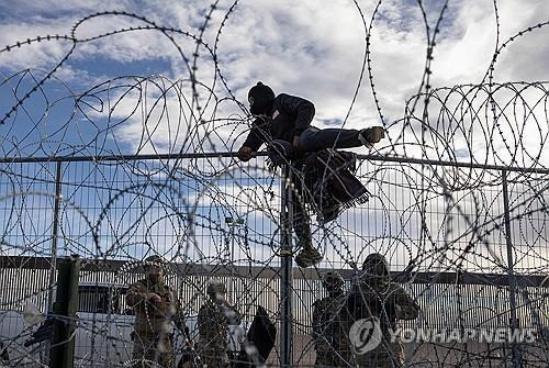 미국 국경 울타리 넘는 베네수엘라 이민자  [AFP 연합뉴스 자료사진]