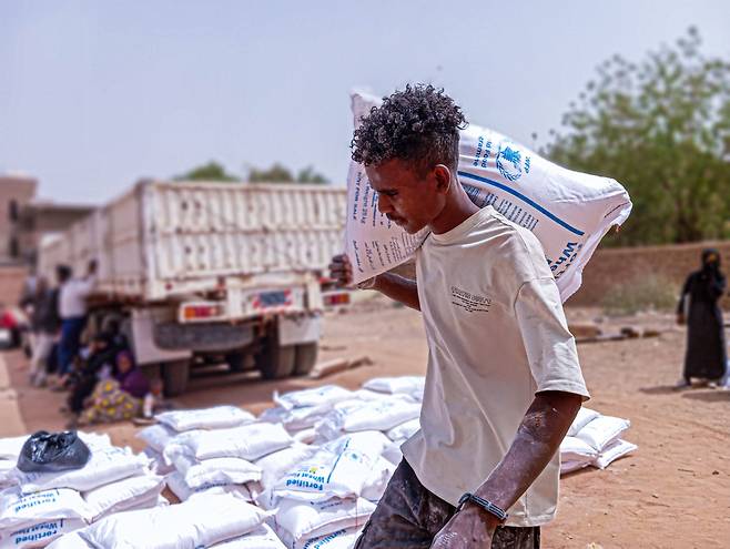 지난 3월 수단의 수도 하르툼에서 한 수단인이 유엔식량계획(WFP)의 구호품을 나르고 있다./WFP