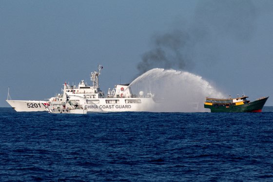 지난 3월 5일 중국 해양경비대 선박이 남중국해에서 필리핀 해경 선박을 향해 물대포를 발사하고 있다. 로이터=연합뉴스