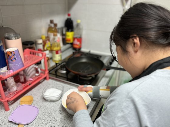 지난 2일 인천에 거주하는 '가족돌봄아동' 구혜빈(12) 양이 오른팔에 보호대를 두르고도 오빠의 저녁식사를 준비하기 위해 계란을 풀고 있다. 혜빈 양은 아픈 엄마를 대신해 지적장애가 있는 오빠의 식사를 챙긴다. 이보람 기자
