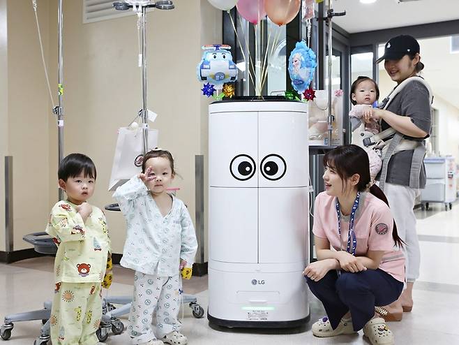 지난 3일 한림대성심병원에서 의료서비스 로봇이 나눠준 어린이날 선물을 받은 소아병동 환자들이 활짝 웃고 있다. 한림대성심병원 제공