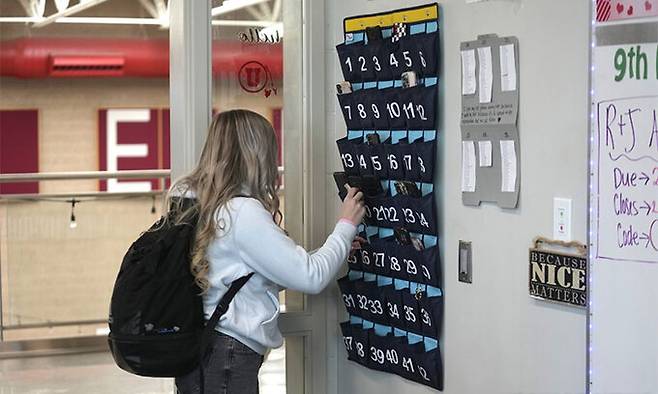 미국 유타주 델타의 한 고등학교에서 학생이 수업에 들어가면서 휴대전화를 거치대에 꽂고 있다. AP연합뉴스