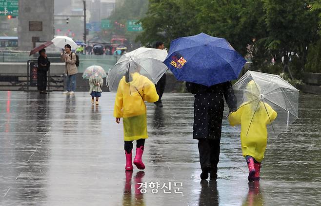 어린이날인 지난 5일 엄마와 함께 서울 광화문광장을 찾은 어린이들이 우산을 쓰고 걸어가고 있다. 서성일 선임기자