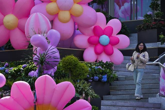 한 여성이 6일 베이징의 꽃과 토끼 모양 조형물 앞을 걸어가고 있다./AP연합뉴스