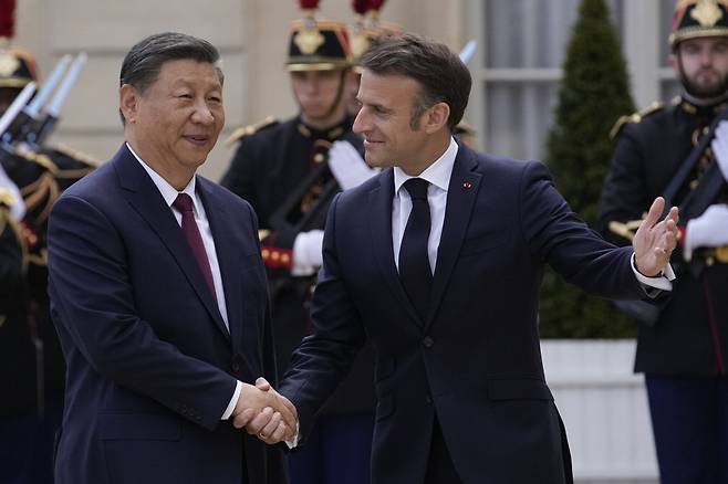 에마뉘엘 마크롱 프랑스 대통령(오른쪽)이 6일(현지시간) 파리 엘리제궁에서 시진핑 중국 국가주석과 회담하기에 앞서 반갑게 악수하고 있다.  AP연합뉴스