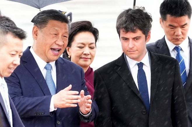 5일 프랑스 방문을 위해 파리 오를리 공항에 도착한 시진핑 중국 국가주석(왼쪽두 번째)이 영접을 나온 가브리엘 아탈 프랑스 총리(오른쪽 두 번째)와 대화를 나누고 있다. 가운데는 시 주석의 부인 펑리위안 여사. AFP연합뉴스