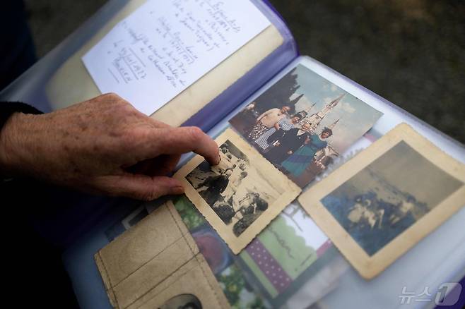 마리-아닉-살론이 프랑스 북서부 르 드레네크 지역에서 미군 성폭행 피해자인 어머니 카트린 투르넬렉의 사진을 보여주고 있다. 2024.03.14 ⓒ AFP=뉴스1 ⓒ News1 정지윤 기자