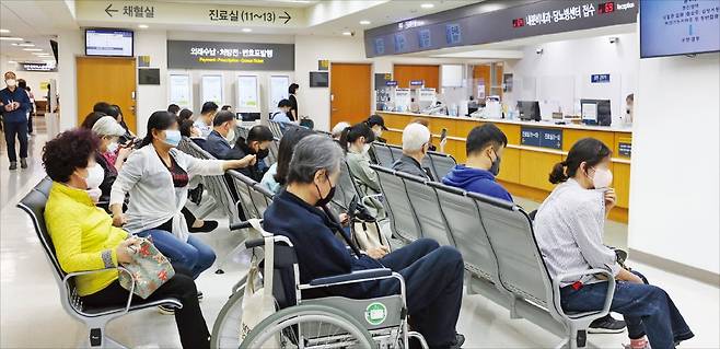 < 대기하는 환자들 > 26일 서울 신촌세브란스병원을 찾은 환자와 보호자들이 접수·수납창구 앞에 앉아 대기하고 있다. 연세대의대 교수 비상대책위원회가 오는 30일 집단 휴진을 선언했지만 상당수 교수는 정상 진료할 것으로 알려졌다.   /이솔 기자