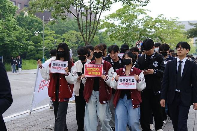 충북대학교 학생자치기구인 중앙운영위원회 구성원들이 7일 대학 내에서 손 팻말을 들고 새 교명 공모를 반대하는 거리 행진을 하고 있다.(사진=충북대 학생자치회 제공).2024.05.07.photo@newsis.com *재판매 및 DB 금지