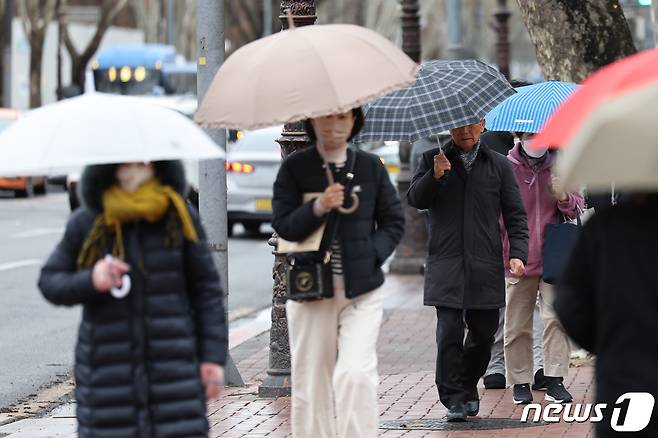 5일 오전 서울 종로구 지하철 4호선 혜화역 일대에서 우산을 쓴 시민들이 가는 빗발 아래 걸음을 재촉하고 있다. 2024.2.5/뉴스1 ⓒ News1 민경석 기자