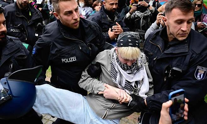 7일(현지시각) 독일 베를린 자유대학교에서 가자 전쟁을 반대하는 시위가 일어나면서 한 참여자가 경찰에 의해 끌려나가고 있다. 베를린/AFP 연합뉴스