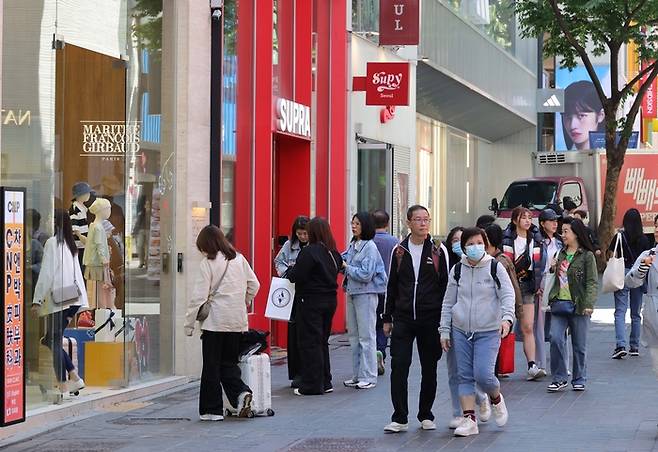 8일 서울 중구 명동에 위치한 패션 브랜드 매장 앞에 여행 가방을 든 외국인들이 몰려들고 있다. [한주형 기자]