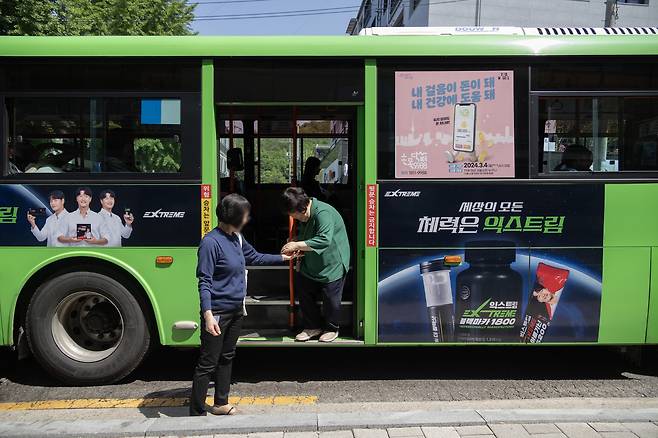 활동지원사가 버스에서 내리는 이성희씨의 손을 잡아주고 있다. ⓒ시사IN 박미소