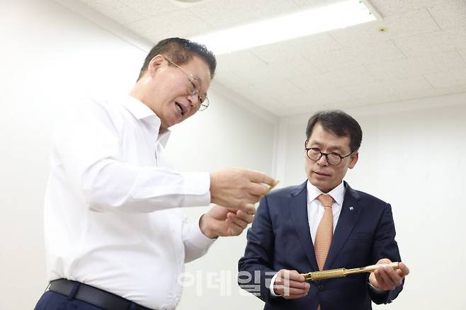 김성태(오른쪽) IBK기업은행장이 9일 성남산업단지에 소재한 하이콘을 방문해 황동원 대표에게 반도체 테스트 소켓에 대한 설명을 듣고 있는 모습.(사진=기업은행)