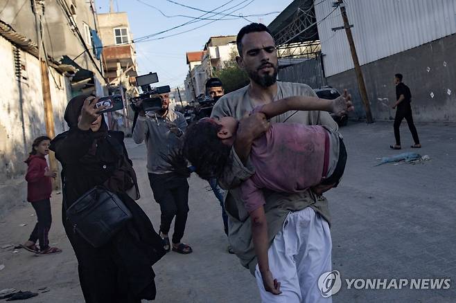 이스라엘군의 폭격에 다친 어린이를 옮기는 라파 주민들 [EPA 연합뉴스자료사진. 재판매 및 DB 금지]