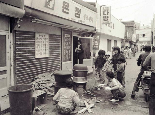 1980년 5월 20일 광주 금남로에서 치열한 투석전이 벌어지는 동안 골목 식당 앞에선 시민들이 큰 솥을 걸고 시민군에게 줄 주먹밥을 만들고 있다.