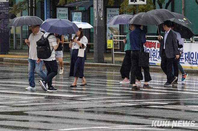 서울 영등포구 국회의사당역 인근에서 우산을 쓴 시민들이 발걸음을 재촉하고 있다. 쿠키뉴스 자료사