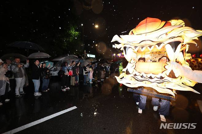 [서울=뉴시스] 김명년 기자 = 부처님오신날을 앞둔 11일 오후 서울 종로 일대에서 우산을 쓴 관람객들이 연등 행렬을 구경하고 있다. 2024.05.11. kmn@newsis.com