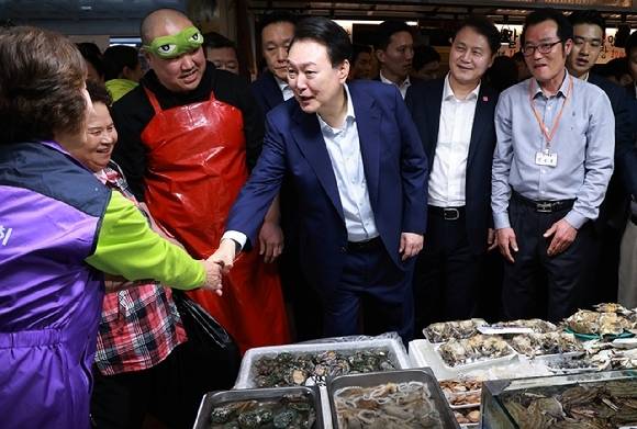 윤석열 대통령이 10일 서울 서대문구 영천시장을 찾아 수산물 가게에서 상인과 인사를 나누고 있다. 대통령실통신사진기자단