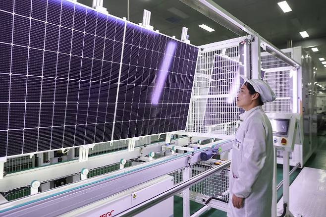 중국 장쑤성 렌윈강의 한 공장에서 직원이 수출용 태양광 모듈 생산 작업을 지켜보고 있다. (사진=AFP)