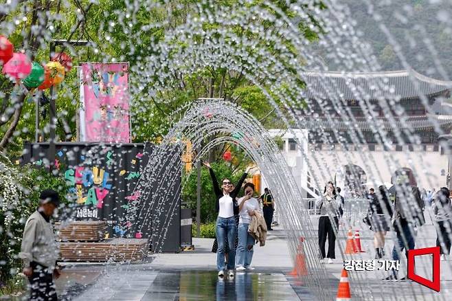전국 대부분 지역 낮 기온이 25도 이상으로 상승한 26일 서울 종로구 광화문 광장을 찾은 외국인이 분수터널을 거닐며 더위를 식히고 있다. 사진=강진형 기자aymsdream@