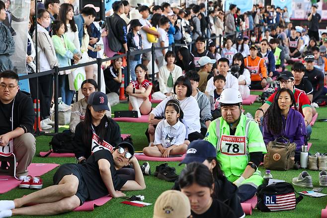12일 오후 서울 반포한강공원 잠수교에서 열린 '2024 한강 멍때리기 대회’에서 참가자들이 허공을 바라보고 있다./연합뉴스