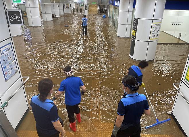 지난 2022년 8월 서울지하철 7호선 이수역이 흘러내린 빗물로 침수되자 청소노동자들이 배수작업을 하고 있다. 서성일 기자