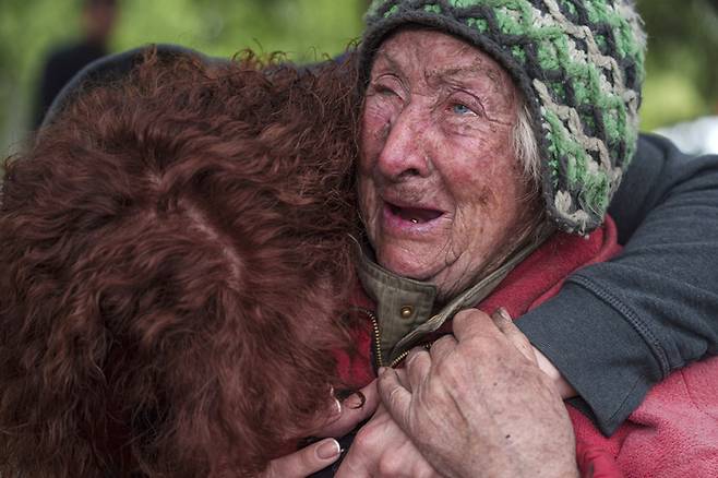 11일(현지시간) 우크라이나 동북부 하르키우주 보우찬스크에서 러시아군의 공격이 시작되자 82세 여성 타티아나가 딸과 함께 대피하며 울고 있다. 이 여성의 남편은 러시아군의 공습으로 집에서 사망했다. AP연합뉴스