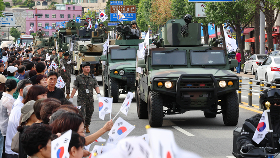 People watch military vehicles passing during a parade held on a street in Incheon to commemorate the 73rd anniversary of the Incheon Landing Operation on Sept. 15, 2023. [YONHAP]