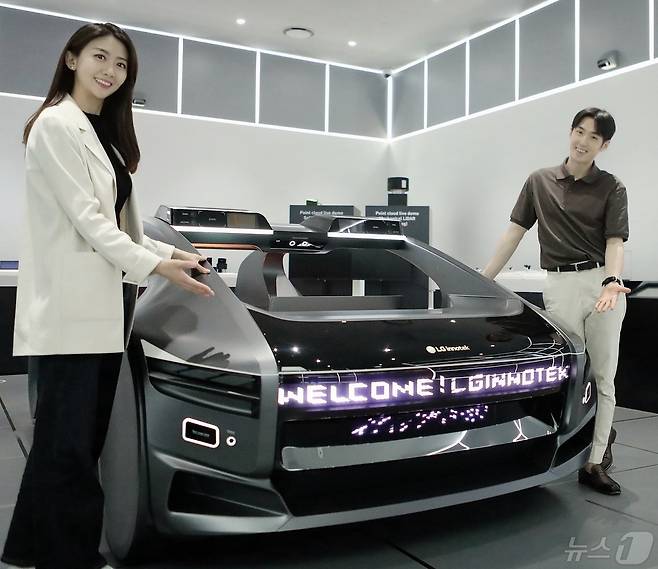 LG이노텍 직원들이 미래차 목업(Mock-up)에 장착된 차량 조명 모듈 ‘넥슬라이드’를 선보이고 있다. (LG이노텍 제공)
