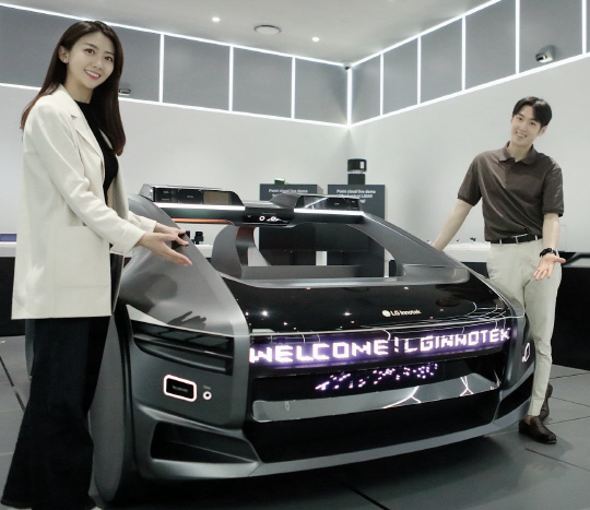LG이노텍 직원들이 미래차 목업(Mock-up)에 장착된 차량 조명 모듈 '넥슬라이드'를 선보이고 있다. LG이노텍 제공