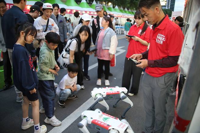 파워풀대구페스티벌에서 이철수 유엔디 대표(오른쪽)가 로봇카페를 방문한 관람객들에게 사족보행로봇을 시연하고 있다.