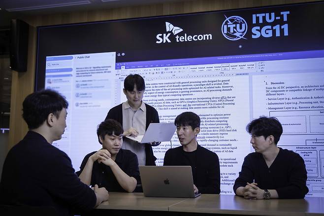 SK Telecom's head of future R&D Lee Jong-min (second from right) and other team members hold a meeting. (SK Telecom)