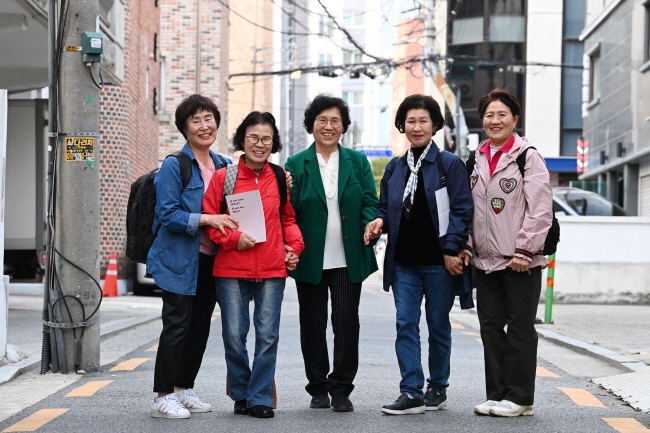 배움의 기쁨 강동야간학교 입학·개학식이 열린 지난 9일 서울 강동구 둔촌동 야학 인근 골목에서 이주성(가운데) 야학 교사와 학생들이 환하게 웃고 있다.  문호남 기자