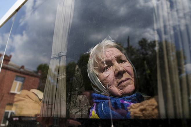 12일(현지시간) 우크라이나 보브찬스크에서 대피하는 시민이 차 창문밖으로 거리를 보고 있다. [AP]