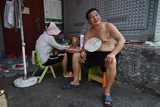 지난해 7월 19일 중국 베이징의 한 골목에서 시민들이 더위를 식히고 있다. (사진=AFP)