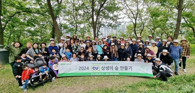 지난 11일 서울 마포구 상암동 노을공원에서 '상생의 숲 만들기' 활에 참여한 BGF리테일 임직원과 CU 가맹점주들이 기념 촬영하고 있다. /BGF리테일