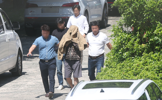 A suspect accused of murdering a Korean national in Pattaya, Thailand, is transferred to the Gyeongnam Provincial Police Agency in Changwon, South Gyeongsang, on Monday for further questioning. He was apprehended at his residence in North Jeolla. [YONHAP]