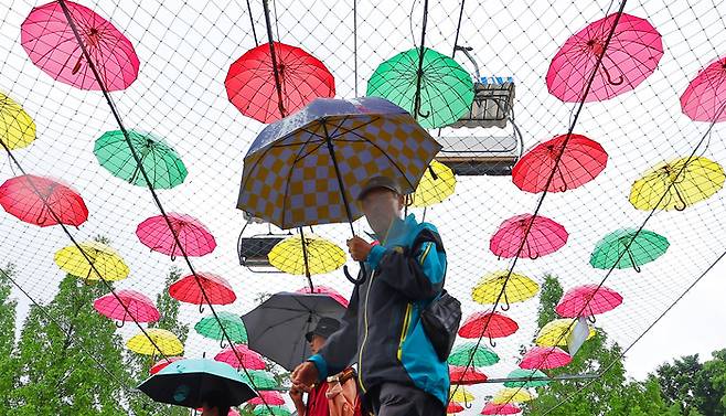 지난 6일 비가 내린 경기도 과천시 서울대공원을 찾은 시민들이 우산을 쓰고 나들이를 즐기고 있다. [사진 = 연합뉴스]
