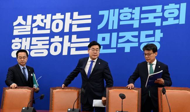 박찬대(가운데) 더불어민주당 원내대표가 14일 오전 국회에서 열린 원내대책회의에 앞서 자리에 앉기 위해 의자를 빼고 있다. 왼쪽은 박성준 원내수석부대표, 오른쪽은 진성준 정책위의장. 곽성호 기자