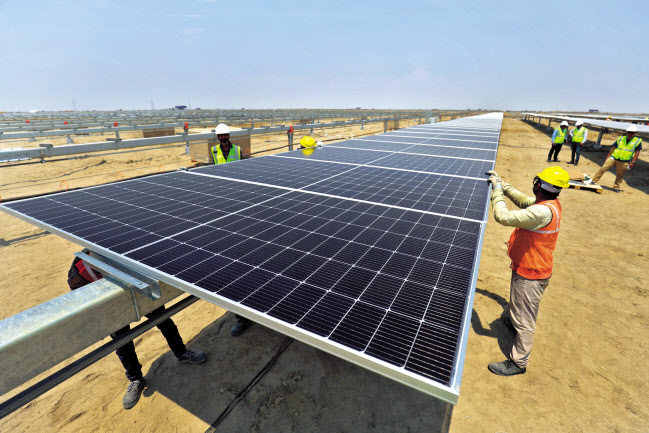 인도 카브다에 있는 아다니그린에너지(AGE)의 카다브재생에너지공원에서 지난달 12일 근로자들이 태양광 패널을 설치하고 있다. [로이터]