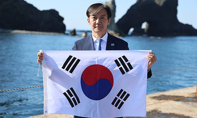 조국혁신당 조국 대표가 13일 경북 울릉군 독도를 찾아 태극기를 들고 기념 촬영하고 있다. 조국혁신당 제공