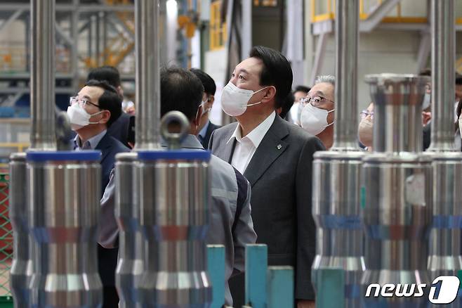 윤석열 대통령이 22일 경남 창원 성산구 두산에너빌리티 원자력 공장을 방문해 김종두 전무의 설명을 들으며 원자로 상부 헤드를 살펴보고 있다. 대통령실사진기자단 2022.6.22/뉴스1 ⓒ News1 안은나 기자