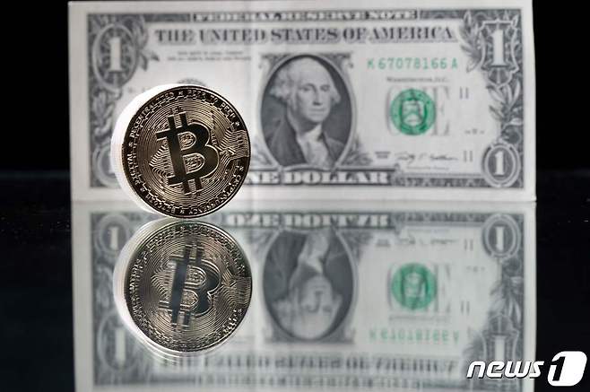 2021년 4월 26일(현지시간) 파리에서 찍힌 미국 1달러 지폐와 비트코인의 이미지를 담은 모조품. ⓒ AFP=뉴스1 ⓒ News1 김지현 기자