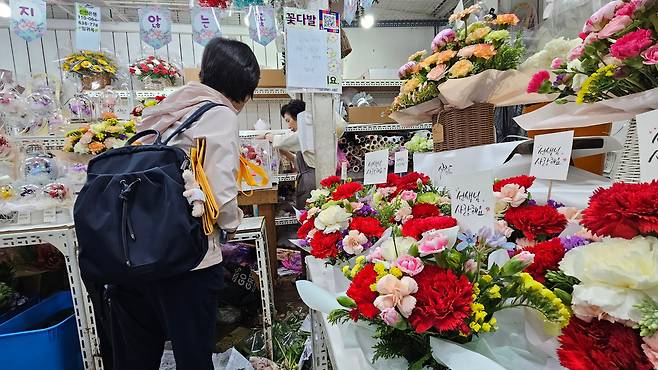 스승의날인 15일 오전 서울 종로구 남대문시장 꽃상가에서 한 시민이 카네이션 꽃다발을 주문하고 있다./강지은 기자