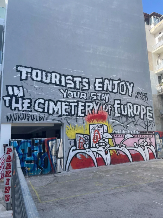 그리스 아테네 주민들 사이에 '반 관광' 정서가 강해지고 있다. 아테네의 한 건물 벽면에 "관광객들은 유럽의 공동묘지에서 즐거운 시간을 보내세요"라는 낙서가 쓰여져 있다. [SNS 캡처]