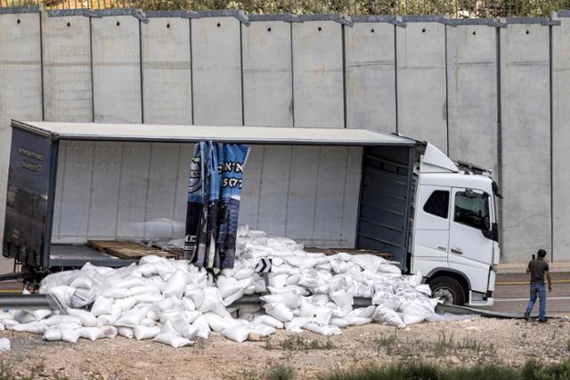 이스라엘 우익 활동가들의 공격을 받은 구호트럭이 13일 서안지구 헤브론 서쪽 셰케프 마을 인근 장벽 앞에 멈춰 서 있다. 셰케프=AFP 연합뉴스
