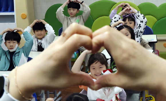 스승의날을 하루 앞둔 14일 부산 남구 용소초등학교 2학년 교실에서 학생들이 담임 교사에게 '손하트'를 만들고 있다. [사진=뉴시스]