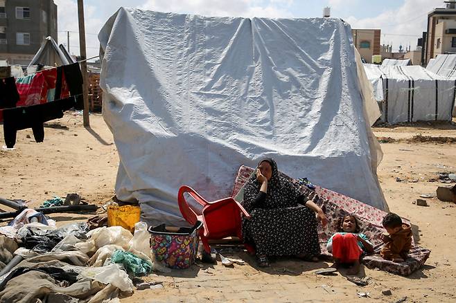 7일(현지시간) 이스라엘군이 지상작전을 개시한 가자지구 라파에서 아직 피란을 떠나지 못한 팔레스타인인들이 피란촌 텐트 앞에 앉아있다.  로이터연합뉴스